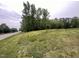 Serene view of a vacant lot with a road nearby, surrounded by lush trees and greenery at 4628 Rogers Rd, Wake Forest, NC 27587