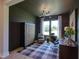 Chic home office featuring a dark accent wall, plaid rug, and ample natural light at 4628 Rogers Rd, Wake Forest, NC 27587