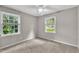 This bright bedroom features two windows and a ceiling fan at 5002 Kendridge Dr, Durham, NC 27712