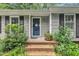Inviting front entrance with brick steps, a dark-colored door, and well-maintained landscaping at 5002 Kendridge Dr, Durham, NC 27712