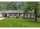 Charming single-story home with lush front lawn, mature trees, and traditional architectural details at 5002 Kendridge Dr, Durham, NC 27712