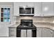 Close-up of the modern kitchen featuring stainless steel appliances, granite countertops, and bright white cabinets at 5002 Kendridge Dr, Durham, NC 27712