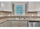 Well-lit kitchen features a stainless steel sink, granite countertops, stylish backsplash, and modern appliances at 5002 Kendridge Dr, Durham, NC 27712