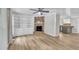 Living room featuring fireplace with brick surround, built in shelves and cabinets, ceiling fan, and wood floors at 5002 Kendridge Dr, Durham, NC 27712
