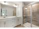 Bathroom with double vanity, large mirror, and glass shower door, and tiled shower at 501 Hazy Hills Ln, Garner, NC 27529