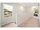 Carpeted hallway with railing, window, and a view into a bedroom at 501 Hazy Hills Ln, Garner, NC 27529