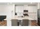 Modern kitchen with white cabinets, stainless steel appliances, and a large island with bar stools at 501 Hazy Hills Ln, Garner, NC 27529