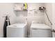 Clean and well-lit laundry room with a washer, dryer, and storage shelf at 501 Hazy Hills Ln, Garner, NC 27529