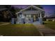 Charming gray home featuring a covered front porch, lovely landscaping, and classic architectural details at 507 S Mebane St, Burlington, NC 27215