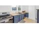 Compact kitchen featuring blue cabinets, butcher block counters, stainless steel appliances, and a tile floor at 507 S Mebane St, Burlington, NC 27215