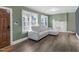 Bright living room with modern gray sofa, decorative fireplace, hardwood floors and natural light from large windows at 507 S Mebane St, Burlington, NC 27215