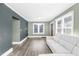 Open living room features hardwood floors, a gray sofa, and abundant natural light through large windows at 507 S Mebane St, Burlington, NC 27215