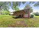 Back exterior showcasing a spacious yard, brick facade, and a walkout basement for added convenience and accessibility at 5932 Johnson Pond Rd, Fuquay Varina, NC 27526