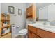 Cozy bathroom featuring a single sink vanity, framed artwork, and a toilet at 5932 Johnson Pond Rd, Fuquay Varina, NC 27526