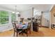 Bright kitchen with a breakfast area featuring a colorful tablecloth, hardwood floors and views of the backyard at 5932 Johnson Pond Rd, Fuquay Varina, NC 27526