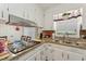 Kitchen features white cabinets, granite countertops, stainless steel sink, a window, and updated appliances at 5932 Johnson Pond Rd, Fuquay Varina, NC 27526