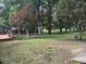 Spacious backyard with mature shade trees, wooden patio deck, and green landscaping at 609 Malone Ct, Burlington, NC 27215