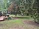 View of the backyard featuring a well-maintained lawn and mature trees at 609 Malone Ct, Burlington, NC 27215