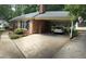 Long paved driveway leading to carport attached to brick house with an exterior door at 609 Malone Ct, Burlington, NC 27215