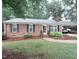 Charming brick home with a carport, well-manicured lawn and established landscaping at 609 Malone Ct, Burlington, NC 27215