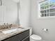 Bright bathroom features granite countertop, sleek vanity, white toilet, and window with natural light at 635 Black Angus Dr, Haw River, NC 27258