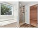 Luxury bathroom features a soaking tub, glass shower, and views of the exterior through windows at 635 Black Angus Dr, Haw River, NC 27258