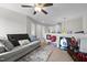 A spacious bonus room with carpet, featuring a gray couch, ceiling fan, and open layout at 635 Black Angus Dr, Haw River, NC 27258