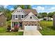 Charming two-story home featuring stone accents, a two-car garage, and manicured lawn at 635 Black Angus Dr, Haw River, NC 27258