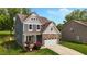 Charming two-story home featuring stone accents, a two-car garage, and manicured lawn at 635 Black Angus Dr, Haw River, NC 27258