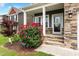 Inviting front porch with stone steps, flowering bushes, and Craftsman-style details at 635 Black Angus Dr, Haw River, NC 27258