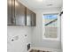 Practical laundry room with overhead cabinets and natural light from a window at 635 Black Angus Dr, Haw River, NC 27258