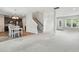 Open-concept living room and kitchen area with stairs, neutral carpet, and light-colored walls at 635 Black Angus Dr, Haw River, NC 27258