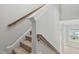 Carpeted staircase with stained wood handrails, leading to a view of the backyard at 635 Black Angus Dr, Haw River, NC 27258