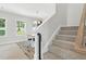 Carpeted staircase leads to an open dining area filled with natural light from nearby windows at 635 Black Angus Dr, Haw River, NC 27258