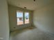 Bright bedroom featuring two windows offering ample natural light in a new construction home at 682 Old Station Pointe, Angier, NC 27501
