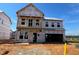 Exterior view of new construction with a covered porch and two-car garage at 682 Old Station Pointe, Angier, NC 27501