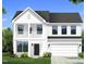 Charming two-story white home with a welcoming front porch and a two-car garage at 682 Old Station Pointe, Angier, NC 27501