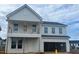 Two-story home showcasing the modern design with neutral siding, covered porch, and an attached two-car garage at 682 Old Station Pointe, Angier, NC 27501