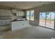 Kitchen featuring white cabinetry, an island, stainless appliances, and sliding glass door access to outdoor living at 682 Old Station Pointe, Angier, NC 27501
