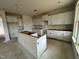 Kitchen with white cabinets, an island, a window and natural light creating a bright space for meal preparation at 682 Old Station Pointe, Angier, NC 27501