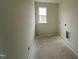 Functional laundry room with a window offering ample natural light in a new construction home at 682 Old Station Pointe, Angier, NC 27501