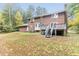 Scenic backyard view of a brick home with a bay window, wooden deck, and a spacious lawn at 6824 Branton Dr, Cary, NC 27519