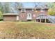 Expansive backyard view featuring a brick home, bay window, and wooden deck overlooking the lawn at 6824 Branton Dr, Cary, NC 27519