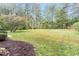 Large, grassy backyard lined with mature trees providing privacy and shade at 6824 Branton Dr, Cary, NC 27519