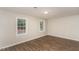 Bedroom featuring hardwood floors, two windows, and neutral paint at 6824 Branton Dr, Cary, NC 27519