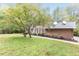 View of the right side of a traditional brick home with manicured lawn and mature trees at 6824 Branton Dr, Cary, NC 27519