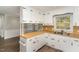 Kitchen with wood countertops, white appliances, window, and new wood flooring at 6824 Branton Dr, Cary, NC 27519