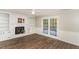 Cozy living room featuring a brick fireplace, built-in shelves, and doors to outdoor patio at 6824 Branton Dr, Cary, NC 27519