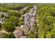 An aerial view showcasing closely built houses nestled amidst lush trees, creating a charming and verdant neighborhood setting at 8308 Society Pl, Raleigh, NC 27615