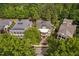 Aerial view of a grand home with a welcoming front porch, manicured landscaping, and a private, tree-lined yard at 8308 Society Pl, Raleigh, NC 27615